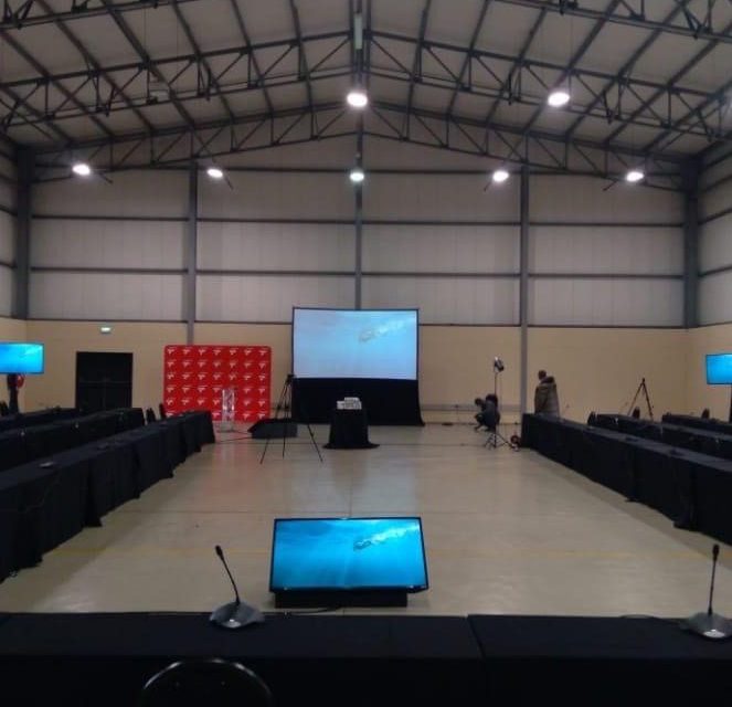 Conference hall set up with screens and microphones
